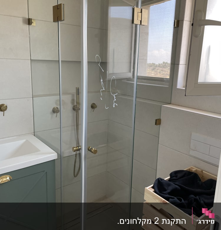 מקלחון זכוכית עם ראש מקלחת עגול ומוט תלייה